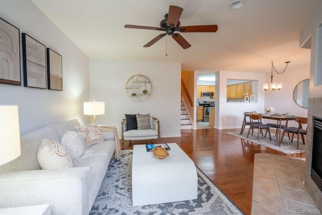 13231 Holly St Unit B, Thornton, CO 80241 - living room featuring stairway, light wood finished floors, a ceiling fan, and a chandelier