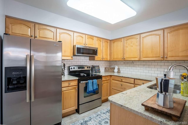 13231 Holly St Unit B, Thornton, CO 80241 - kitchen with appliances with stainless steel finishes, light stone countertops, backsplash, and light tile patterned flooring
