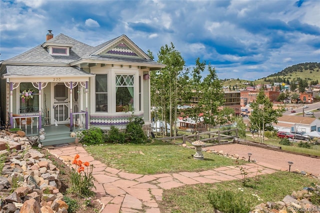 220 E Eaton Ave, Cripple Creek, CO 80813 - victorian-style house with a chimney, covered porch, a mountain view, and a front yard