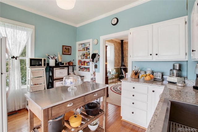 220 E Eaton Ave, Cripple Creek, CO 80813 - kitchen featuring white cabinetry, light wood-style floors, crown molding, and light stone countertops