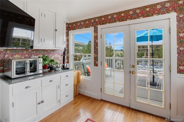 220 E Eaton Ave, Cripple Creek, CO 80813 - doorway to outside with wallpapered walls, light wood-style flooring, french doors, and crown molding