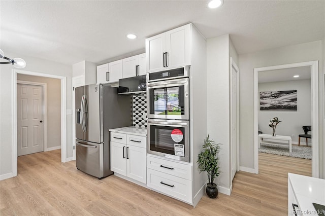 423 Nile St, Aurora, CO 80010 - kitchen featuring appliances with stainless steel finishes, white cabinets, light wood-type flooring, baseboards, and recessed lighting