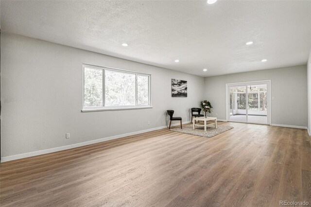 423 Nile St, Aurora, CO 80010 - living area featuring recessed lighting, wood finished floors, baseboards, and a textured ceiling