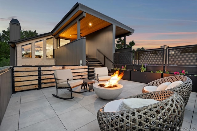 patio terrace at dusk featuring a fire pit