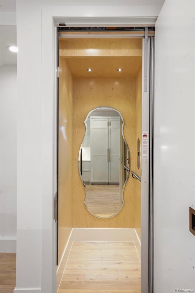 hallway featuring hardwood / wood-style floors and elevator