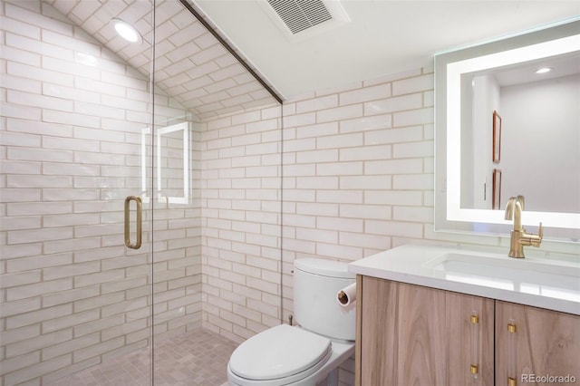 bathroom with lofted ceiling, a shower with door, tile walls, vanity, and toilet