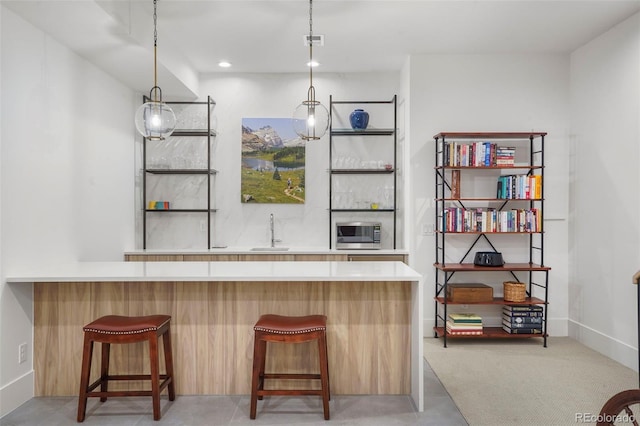 bar with pendant lighting, sink, and light colored carpet