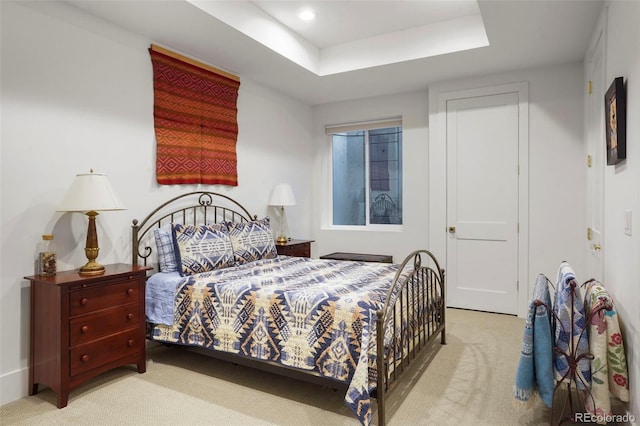 carpeted bedroom with a tray ceiling