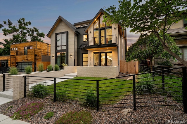 view of front of house featuring a balcony and a lawn