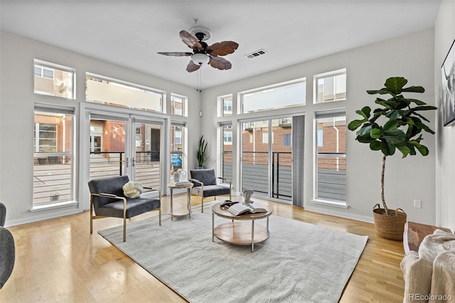 living area with french doors, light wood-type flooring, and ceiling fan