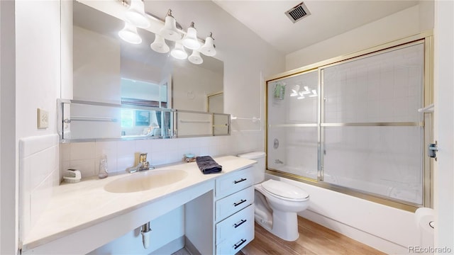 775 S Alton Way Unit 3D, Denver, CO 80247 - full bath with toilet, vanity, tasteful backsplash, bath / shower combo with glass door, and wood finished floors