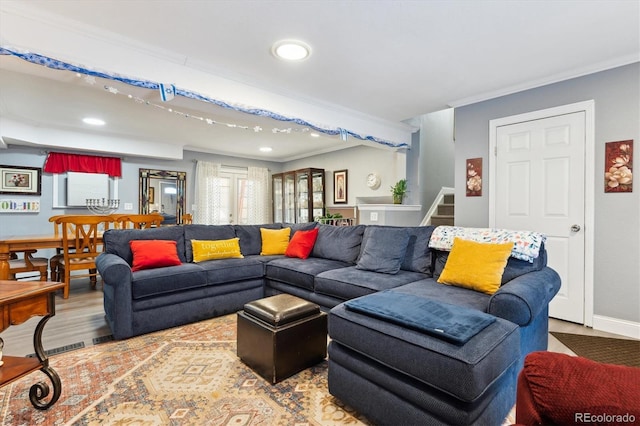 living room featuring ornamental molding and wood-type flooring