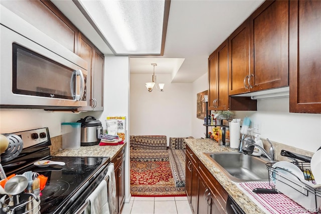 2900 Shadow Creek Dr Unit 201, Boulder, CO 80303 - kitchen featuring appliances with stainless steel finishes, a sink, light tile patterned floors, a chandelier, and light stone countertops