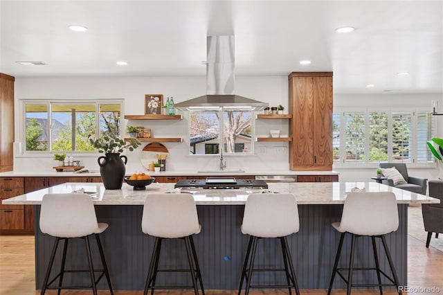 3775 S Forest Way, Denver, CO 80237 - kitchen with open shelves, brown cabinets, recessed lighting, island range hood, and a large island