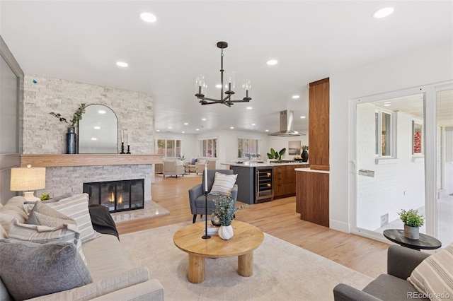 3775 S Forest Way, Denver, CO 80237 - living room featuring wine cooler, light wood-style floors, recessed lighting, a chandelier, and a stone fireplace