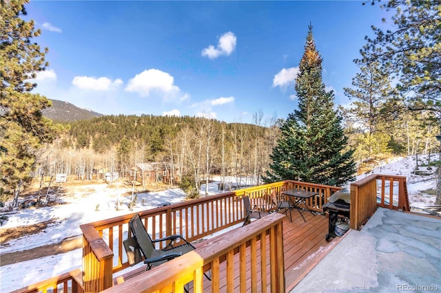 snow covered deck with a mountain view