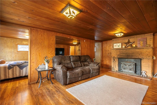 living room with a stone fireplace, wood walls, hardwood / wood-style floors, and wooden ceiling