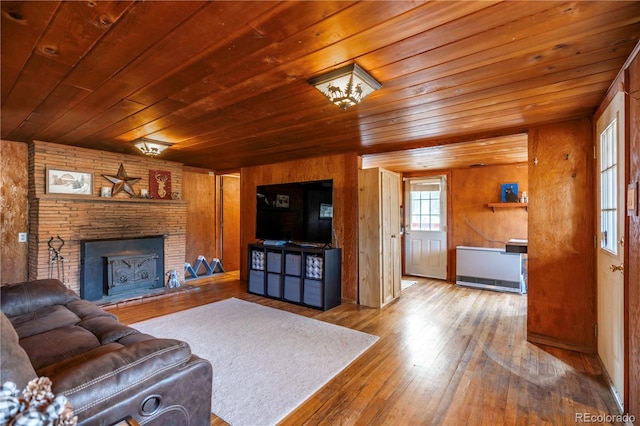 living room featuring a fireplace, hardwood / wood-style floors, wooden walls, and wooden ceiling