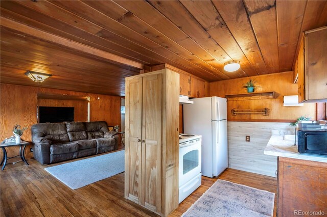 296 Anderson Rd, Bailey, CO 80421 - kitchen with white appliances, under cabinet range hood, wood ceiling, wood walls, and wood finished floors