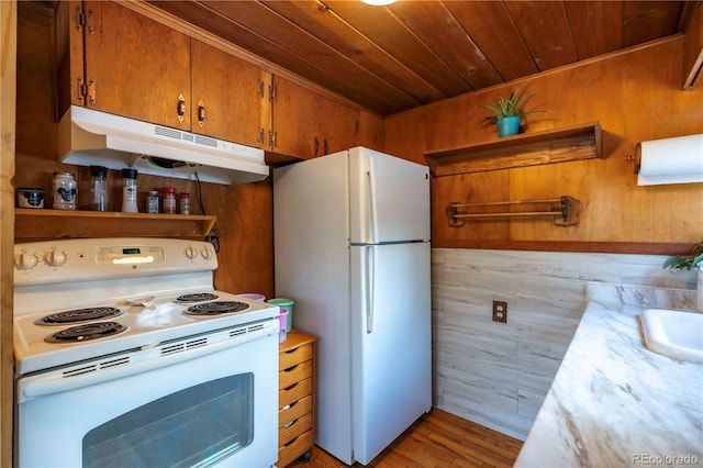 kitchen with wooden walls, wooden ceiling, white appliances, and light wood-type flooring