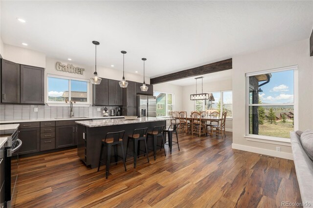 719 Saddle Ridge Cir, Granby, CO 80446 - kitchen featuring stainless steel fridge, a sink, dark wood finished floors, a breakfast bar, and plenty of natural light