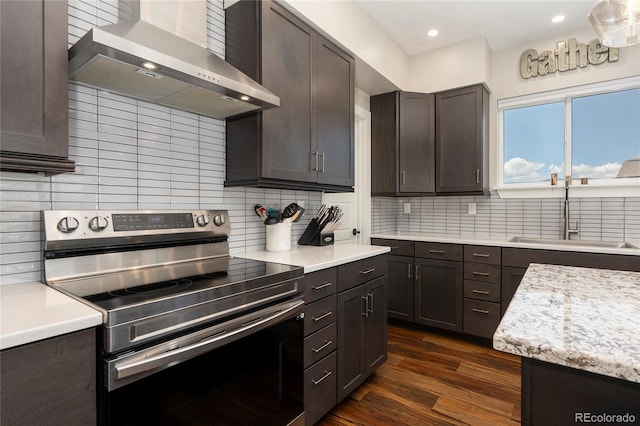 719 Saddle Ridge Cir, Granby, CO 80446 - kitchen with stainless steel electric stove, wall chimney exhaust hood, a sink, dark wood-type flooring, and light countertops