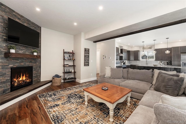 719 Saddle Ridge Cir, Granby, CO 80446 - living area featuring dark wood-style flooring, recessed lighting, baseboards, and a stone fireplace