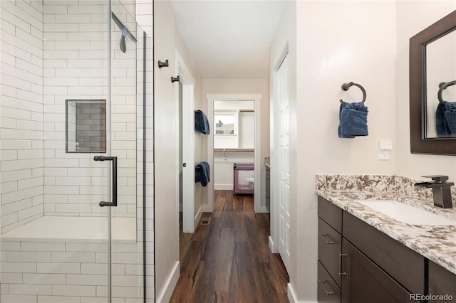 719 Saddle Ridge Cir, Granby, CO 80446 - bathroom with a stall shower, wood finished floors, vanity, and baseboards