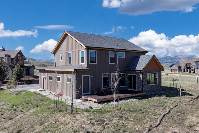 719 Saddle Ridge Cir, Granby, CO 80446 - back of property featuring a deck with mountain view, board and batten siding, and a shingled roof