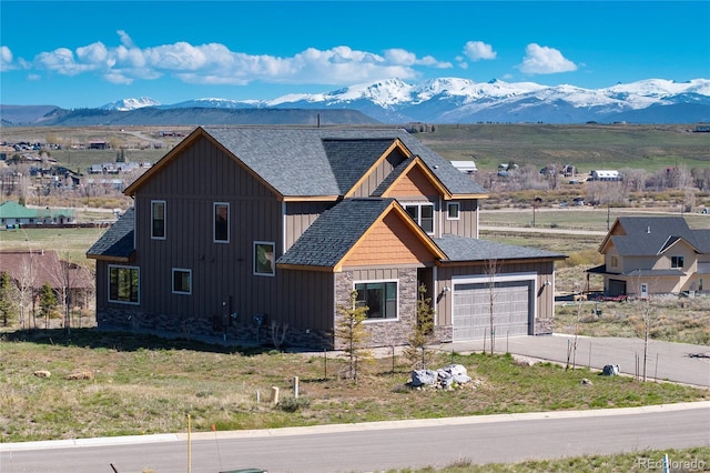 719 Saddle Ridge Cir, Granby, CO 80446 - view of front of property with stone siding, a mountain view, and board and batten siding