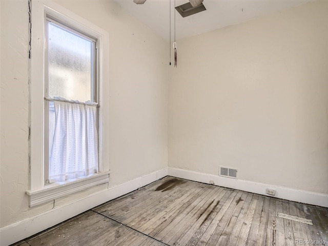 spare room featuring wood-type flooring and plenty of natural light