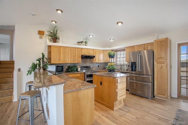 kitchen with open shelves, a center island, under cabinet range hood, appliances with stainless steel finishes, and backsplash