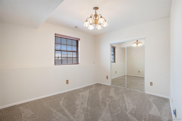unfurnished bedroom with visible vents, carpet floors, baseboards, a closet, and a chandelier