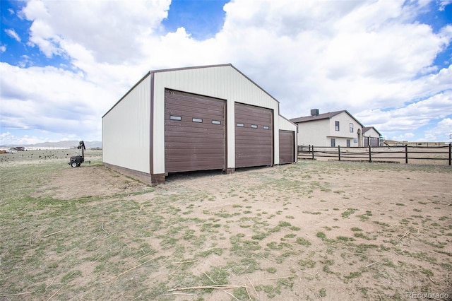 view of outbuilding featuring fence and an outdoor structure