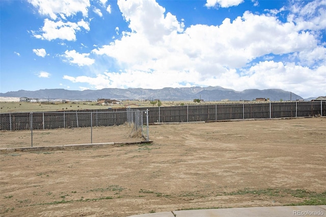 view of yard featuring fence and a mountain view