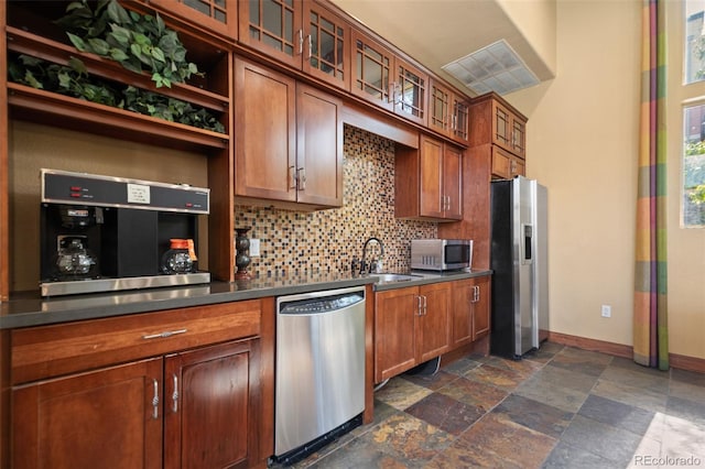 kitchen featuring appliances with stainless steel finishes, backsplash, and sink