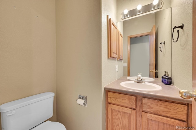 bathroom featuring toilet and vanity