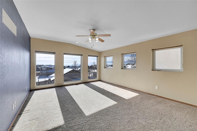 spare room with carpet floors, vaulted ceiling, and ceiling fan