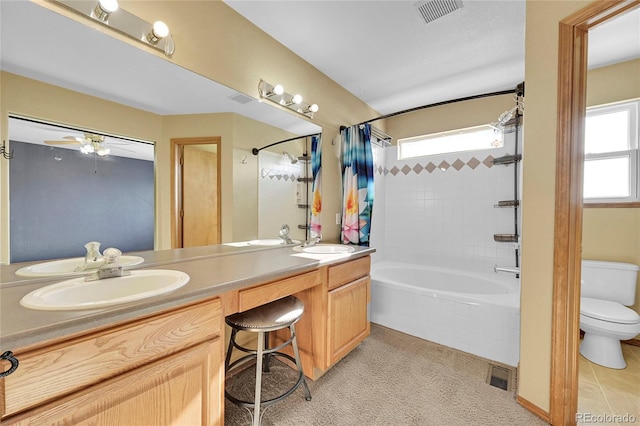 full bathroom with ceiling fan, toilet, vanity, and shower / tub combo with curtain