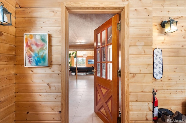 corridor with tile patterned flooring and wooden walls