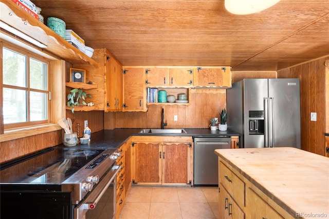 kitchen with sink, light tile patterned floors, wooden walls, stainless steel appliances, and wooden ceiling