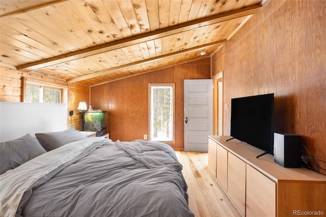 bedroom featuring lofted ceiling with beams, wood walls, wooden ceiling, and light hardwood / wood-style flooring