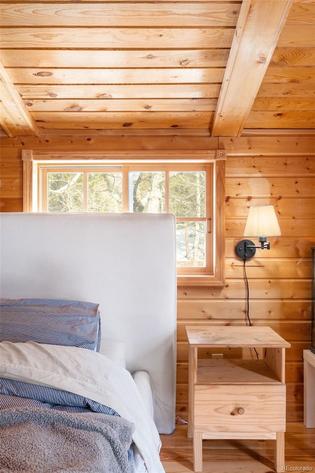 bedroom with multiple windows, hardwood / wood-style floors, wooden walls, and wooden ceiling