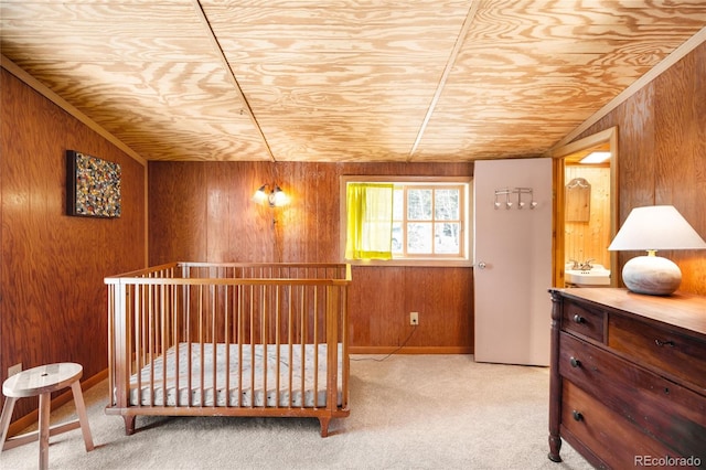 carpeted bedroom featuring wooden walls and vaulted ceiling