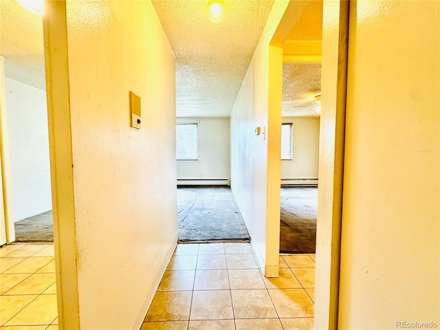 8826 E Florida Ave Unit 102, Denver, CO 80247 - hall featuring light colored carpet, a textured ceiling, light tile patterned floors, and a baseboard heating unit
