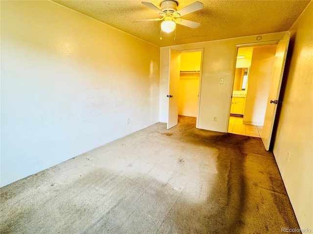 8826 E Florida Ave Unit 102, Denver, CO 80247 - unfurnished bedroom with a ceiling fan, a closet, carpet, a textured ceiling, and a walk in closet