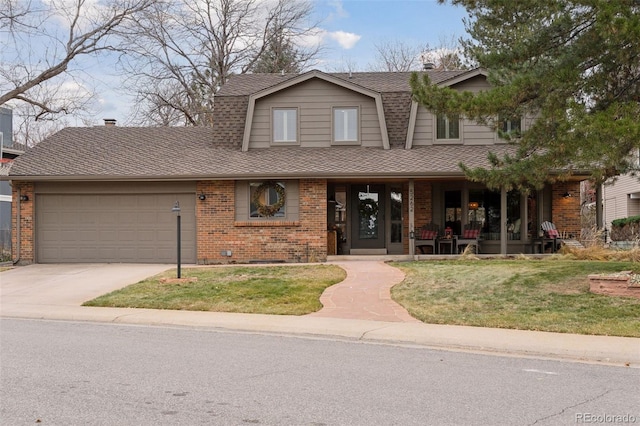 view of front of property with a front yard, a porch, and a garage