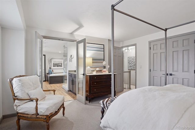 bedroom featuring light carpet and connected bathroom