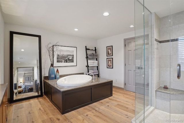 bathroom with separate shower and tub and hardwood / wood-style floors