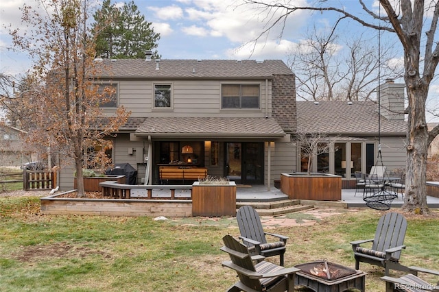 rear view of house with a lawn, a patio area, and an outdoor fire pit